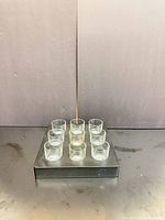 Front angled view showing all nine shot glasses seated in black display tray