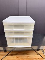 front view showing white plastic frame and three translucent drawers