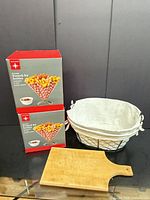 Overall lot: two boxed fry holders, wire basket with liner, wood cutting board