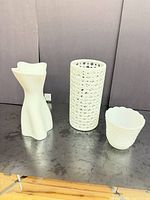 Three white ceramic vases on table