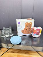 Wilton 3-D bear pan box, mini bear pan box, castle pan, stack of blue plates