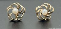 Front view of both gold floral stud earrings with pearls