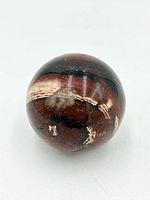 Overall view of polished jaspilite sphere showing layered bands