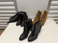 Three pairs of boots on table; target Adrienne Vittadini black ankle boots front centre