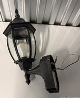 Full view of lantern showing glass panels, bulb, arm and mounting base
