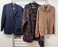 Full view of all three garments hanging: navy blazer, floral coat, brown sweater