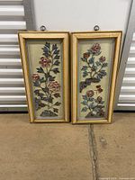 Both framed floral sculptures side by side