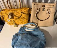 Group shot of yellow, beige and blue handbags