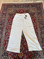 Full view of white cotton wide-leg pants laid flat