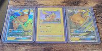 Three sleeved Pokémon cards side-by-side
