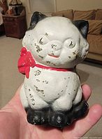 Front view of cast iron kitten coin bank showing paint scheme and overall form