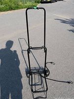 Front view of folded-out hand truck on pavement with cords attached