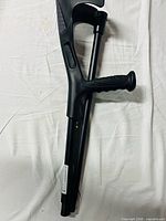 Upper section of black forearm crutch showing cuff and ergonomic handle