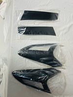 four carbon-fiber pattern plastic trim covers in original packaging: two rectangular and two sculpted