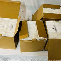 Five cardboard boxes opened to show stacks of white humidifier wick filters