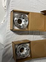 Two boxed aluminum wheel spacers, tops removed to show spacers