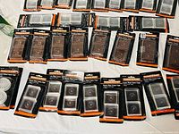Wide view of all sealed packages of square caster cups laid out on table