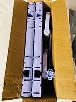Folded purple ab machine inside original box