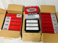Three boxes of Service Champ air filters, middle box open displaying filter, visible part numbers AF5779 and WAF4033