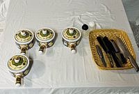 Overview of all saucepans with lids, basket of knives, squeeze bottles