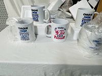 Group of mugs, some still wrapped, showing different French prints