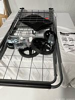 Unassembled cart frame, wheels, hardware and liner on table