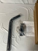 One metal arm wrapped in plastic, bag with hardware and instructions