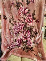 Full view of pink floral acrylic blanket spread out