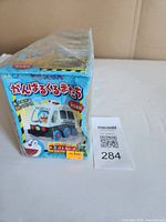 Front view of shrink-wrapped Doraemon moving car box showing police car graphic