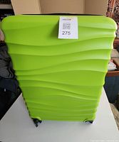 Front view of lime green hard shell suitcase with lot tag