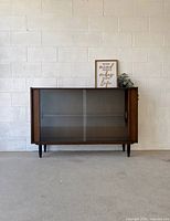 Front view of walnut cabinet with sliding glass doors