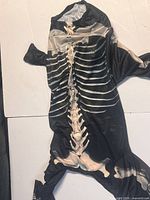 Full view of skeleton print dog jumpsuit laid flat