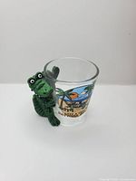 Front view of shot glass showing alligator figure and beach scene graphic