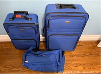 Front view of all three blue luggage pieces