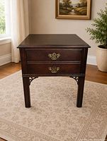 Front view of Ethan Allen side table showing two drawers, brass pulls, corner brackets, tapered legs
