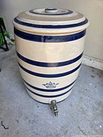 Full view of crock with lid, showing blue banding, crown mark and metal spigot