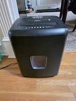 Front view of AmazonBasics shredder showing bin window and power cord