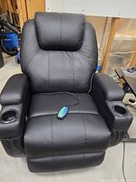 Front view of recliner showing upholstery, cup holders and remote