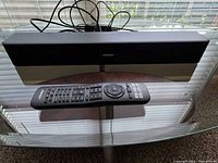 Front view of soundbar with remote and cables