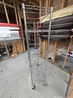 Full view of chrome wire rack showing narrow profile, casters visible