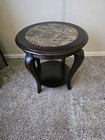 Full view of round end table showing faux marble inset and lower shelf