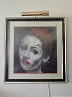 Full view of framed clown portrait with attached picture light