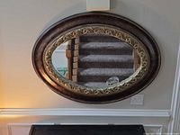 Front view of oval mirror on wall showing full frame detail