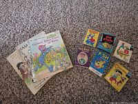 Group shot of four books and six card-game boxes on carpet