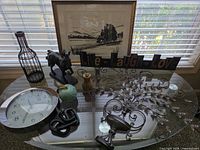 Group view of wall urn, sign, art, horse, clock, wire bottle, apple, pineapple candle holder, knot