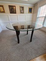 Full view of the glass top table showing shape and leg design