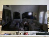 Front view of Sharp 65" TV powered off on mantel