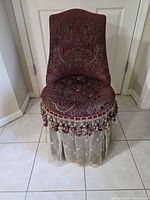Front view showing upholstery, tufting, skirt and fringe