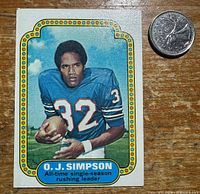 Front of 1974 Topps O. J. Simpson card next to U.S. quarter for scale