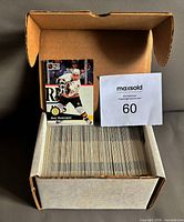 Open cardboard long box filled with trading cards, showing top card Ray Bourque from 1991-92 Pro Set